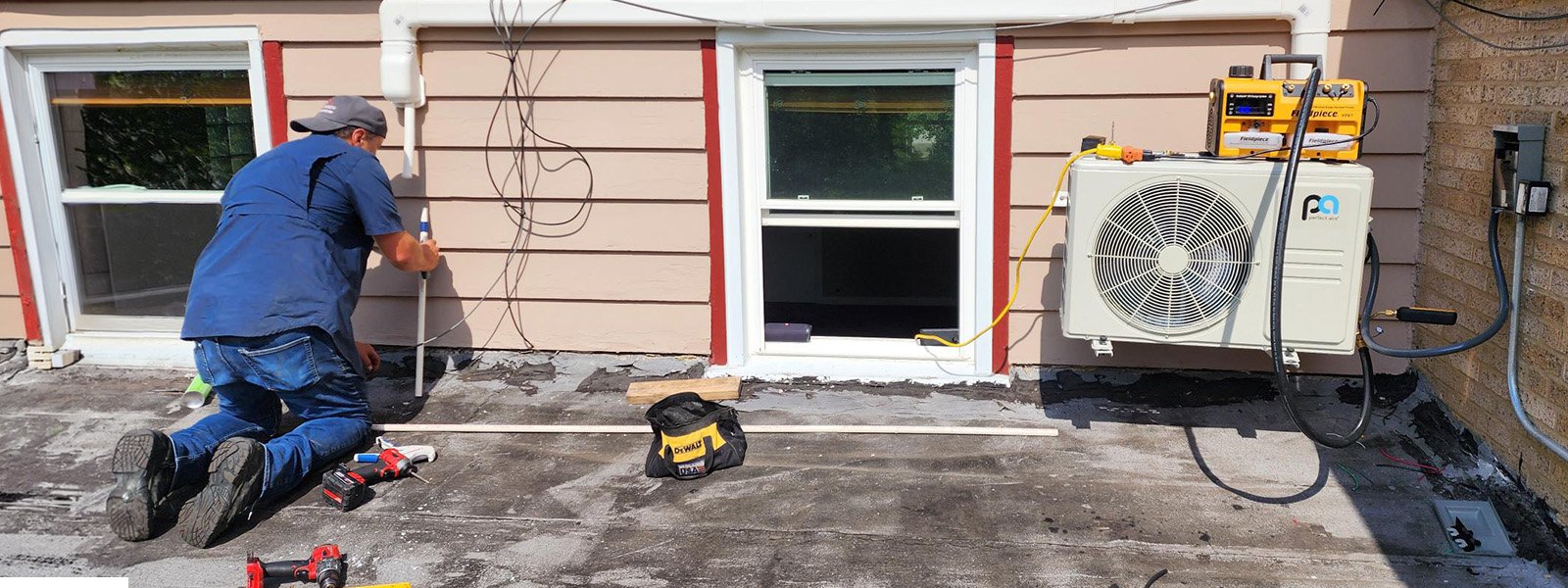 Ductless Direct technician installing a mini-split outdoor condenser on a Chicagoland home
